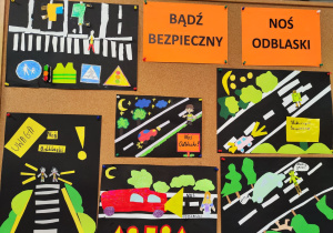 Na tablicy korkowej wiszą prace na temat noszenia odblasków. Widać również napis "Bądź bezpieczny, noś odblaski"