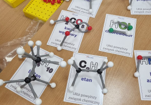 gotowe modele atomów, pod każdym modelem znajduje się karteczka z opisem