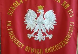 Na pierwszej stronie sztandaru na czerwonym tle widnieje orzeł i nazwa szkoły.
