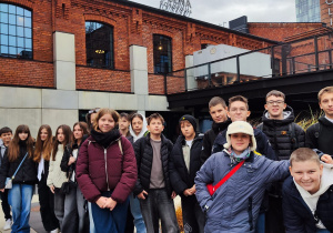 Na dworze przed wejściem do teatru Scena Monopolis stoją uczniowie