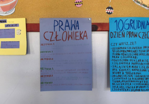 Na tablicy korkowej wiszą plakaty wykonane przez dzieci. Na plakatach znajdują się informacje na temat praw człowieka.