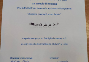 Dyplom naszej uczennicy za zajęcie drugiego miejsca w konkursie. Na białej kartce niebieską czcioną napisane jest imię i nazwisko oraz miejsce i nazwa konkursu.