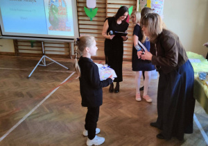 W sali gimnastycznej organizatorzy konkursu wręczają nagrode naszej uczennicy.