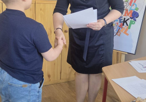 W bibliotece pani dyrektor wręcza dyplom uczestnikowi konkursu
