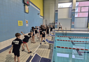 Uczniowie na basenie przygotowują się do zawodów.