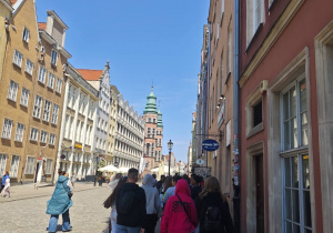 Uczniowie idą ulicą. W głębi kadru widać Bazylikę Mariacką w Gdańsku.