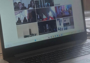 Na ekranie laptopa widać dziewięć okienek z młodzieżą zgromadzoną na spotkaniu on-line.