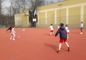 na boisku szkolnym grupa dzieci uczestniczy w zajęciach sportowych