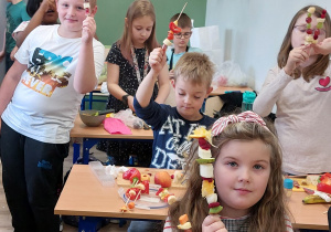 dzieci prezentują wykonane przez siebie warzywno-owocowe szaszłyki