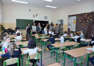 w klasie dzieci siedzą w ławkach rozmawiają z gośćmi z Ukrainy