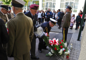 żołnierze składają kwiaty pod tablicą pamiątkową