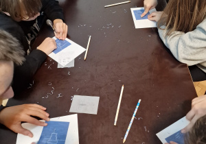 na zdjęciu widać stół, na którym uczniowie wykonują linoryt - obrazki związane z Łodzią