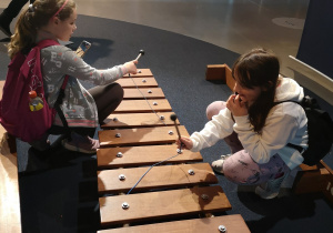 dwie dziewczynki przy dużych cymbaław w Centrum Nauki Kopernik