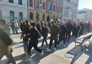 Uczniowie naszej szkoły w polonezie idą parami ulicą Piotrkowską