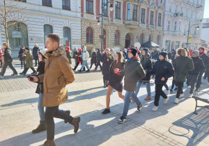 Uczniowie naszej szkoły w polonezie idą parami ulicą Piotrkowską