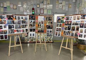 Na szkolnym korytarzu stoją trzy sztalugi. Na każdej znajduje się tablica korkowa, na której powieszone są zdjęcia uczniów, którzy wcielali się w postacie ze słynnych obrazów.