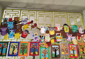 Na kracie na korytarzu wiszą prace uczniów. Są to kolorowe sowy oraz obrazki o tematyce jesiennej