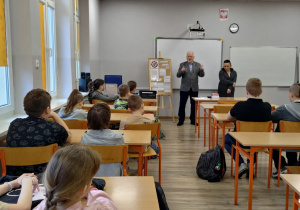 W sali lekcyjnej siedzą uczniowie w ławkach. Trwa spotkanie koła Towarzystwa Przyjaciół Łodzi.